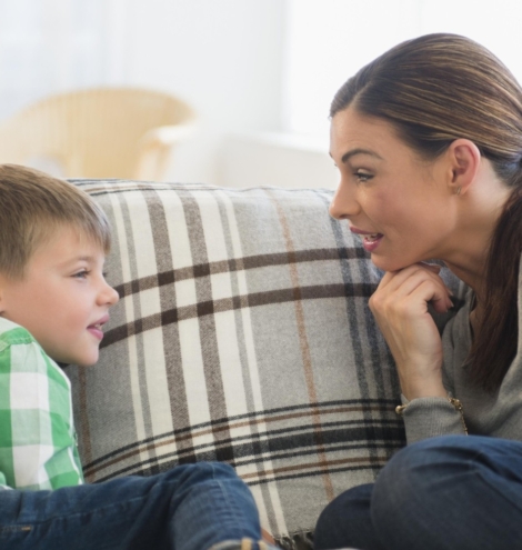 Mother and son (6-7) sitting on sofa