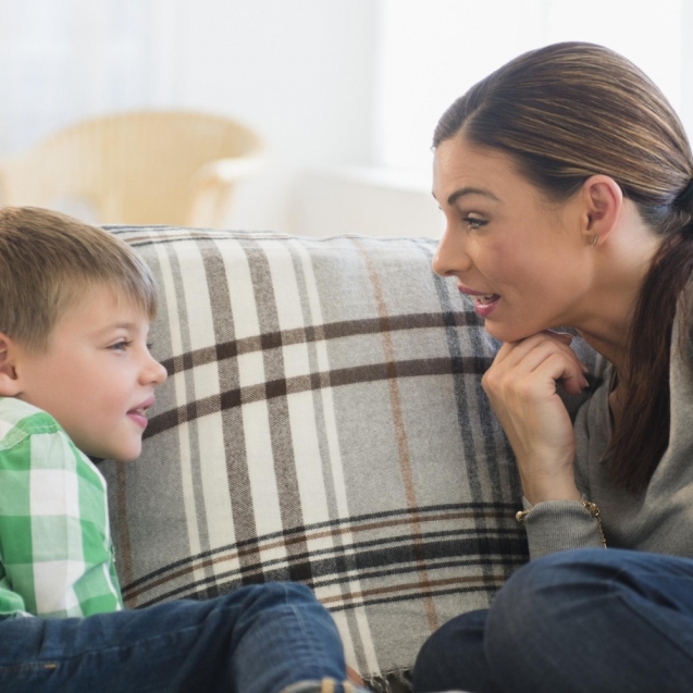 Mother and son (6-7) sitting on sofa